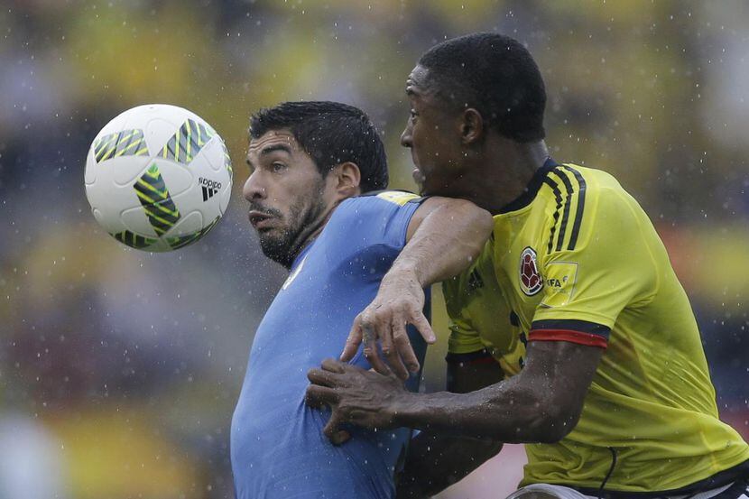 Luis Suárez (izq.) y Oscar Murillo pelean por el balón en el partido entre Uruguay y...