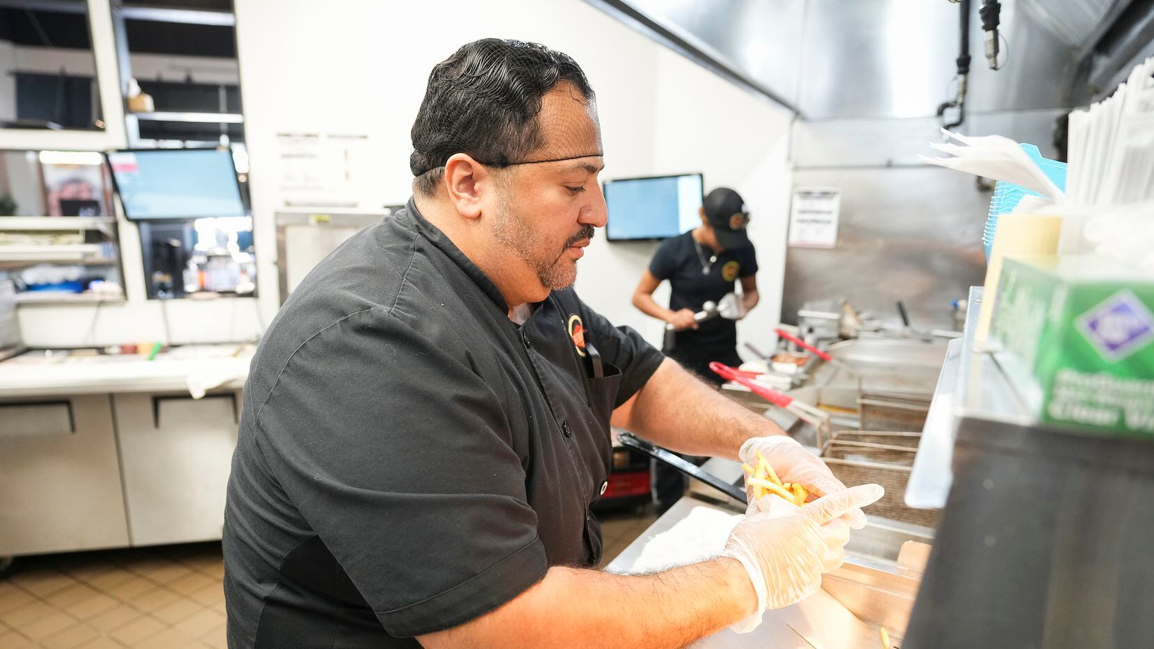 El dueño de Fatburger, Alf González, trabaja enla cocina del restaurante en los Allen...