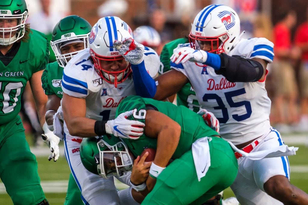 UNT quarterback Mason Fine (6) is sacked by SMU linebacker Richard Moore (14) and defensive end Delontae Scott (35) during the first half of an NCAA football game at Ford Stadium on Saturday, Sept. 7, 2019, in Dallas.