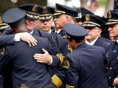Dallas police command staff comfort one another after the burial of Officer Rogelio Santander.
