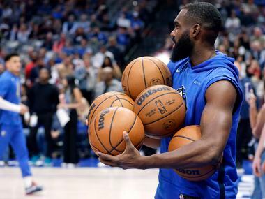 Dallas Mavericks forward Tim Hardaway Jr. (11) balances armfuls of basketballs as he divvies...