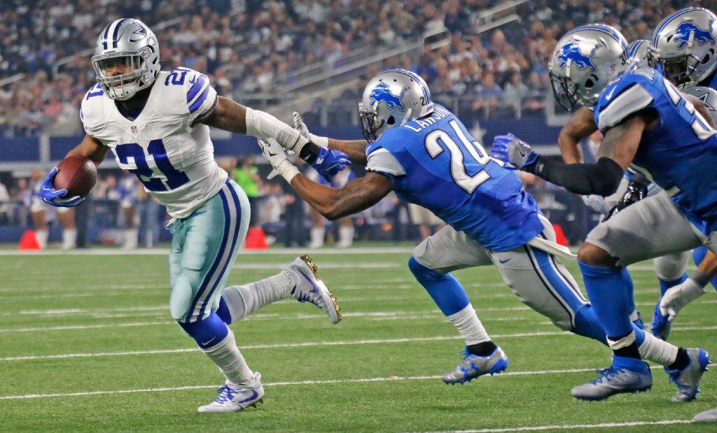 Dallas Cowboys running back Ezekiel Elliott (21) breaks away from a group of Lions defenders...