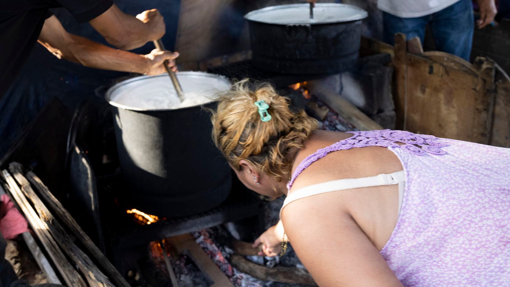 Migrants prepare meals to share with other migrants at Plaza de la República, a public...
