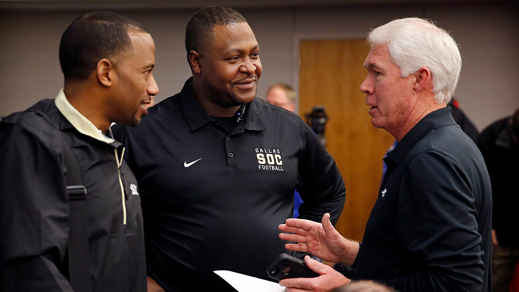 Southlake Carroll head football coach Hal Wasson, right, visits with South Oak Cliff head coach Emmett Jones, left, and assistant Wayne Ingram after the new UIL realignment was announced at Birdville Fine Arts/Athletic Complex in North Richland Hills, Monday, February 3, 2014.
