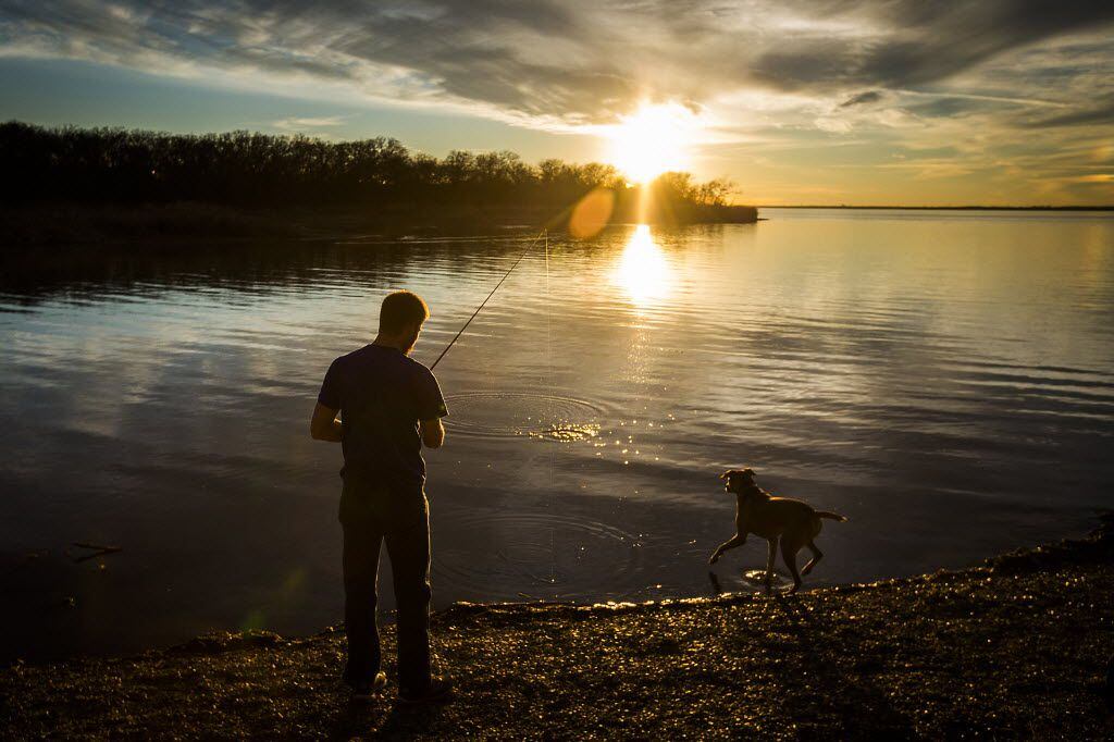 William Christie casts a line as he fishes with his dog at Joe Pool Lake