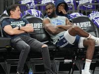 Dallas Mavericks owner Mark Cuban talks with forward Tim Hardaway Jr. as they watch the...