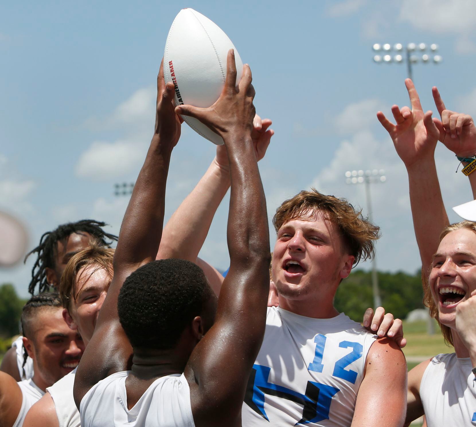 Chris Workley (12) is joined by teammates as they celebrated by raising the Division 1 Championship football which was presented to the Hawks following their 28-26 victory over Lake Travis. The state 7 on 7 football tournament attracted athletes from schools throughout the state. The competition brackets for the final day of competition was held at Veterans Park in College Station on June 25, 2021. (Steve Hamm/ Special Contributor)