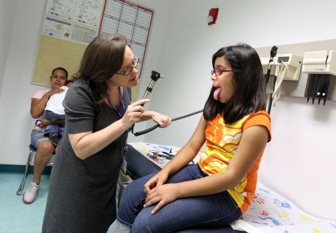 La doctora Emily Sloan realiza una revisión médica a Verónica Aguilar en la Clínica Los Barrios Unidos, en Dallas. Un estudio de Georgetown University afirma que un millón de niños han perdido su cobertura médica en los últimos tres años.