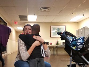 Volunteer Maddy Haas hugs Jamil, a 4-year-old homeless boy whose December birthday was among...