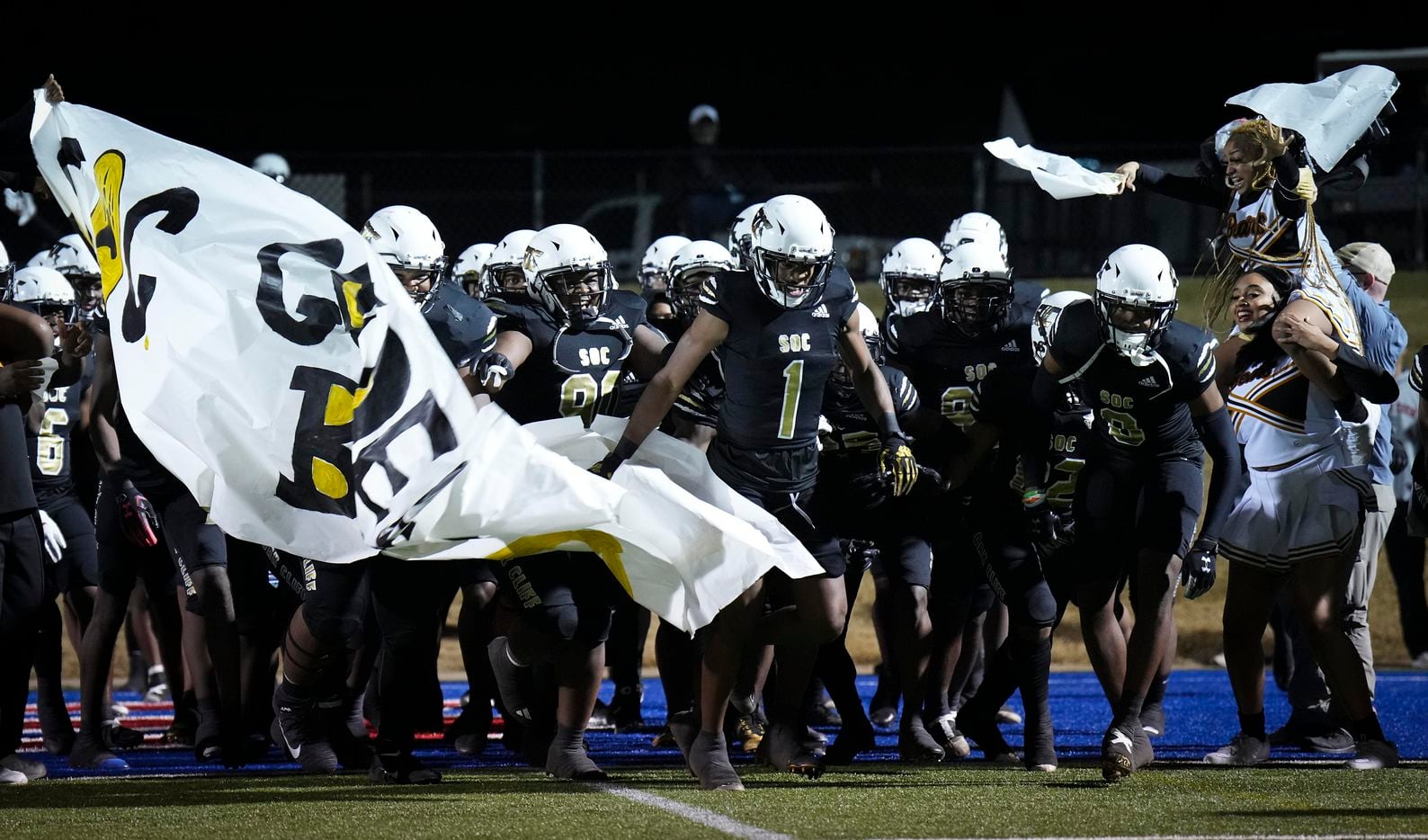 South Oak Cliff defensive back Malik Muhammad (1) leads the team through the banner as they...