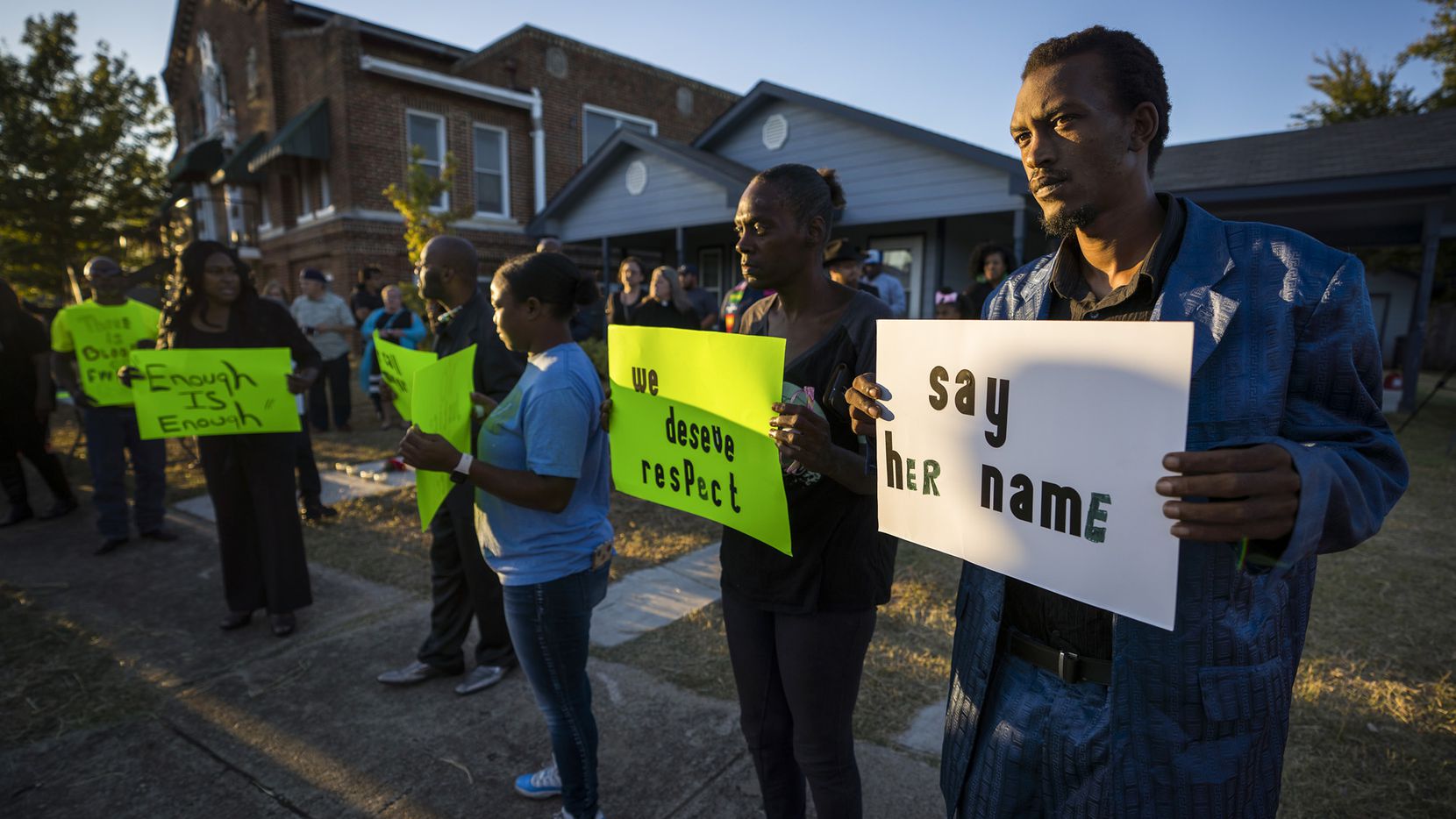Protestors gather outside the house (right) where Atatiana Jefferson was shot and killed,...