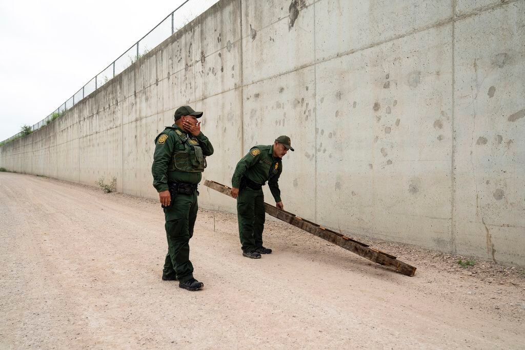 ARCHIVO - Agentes de la Patrulla Fronteriza retiran una escalera usada por migrantes para...