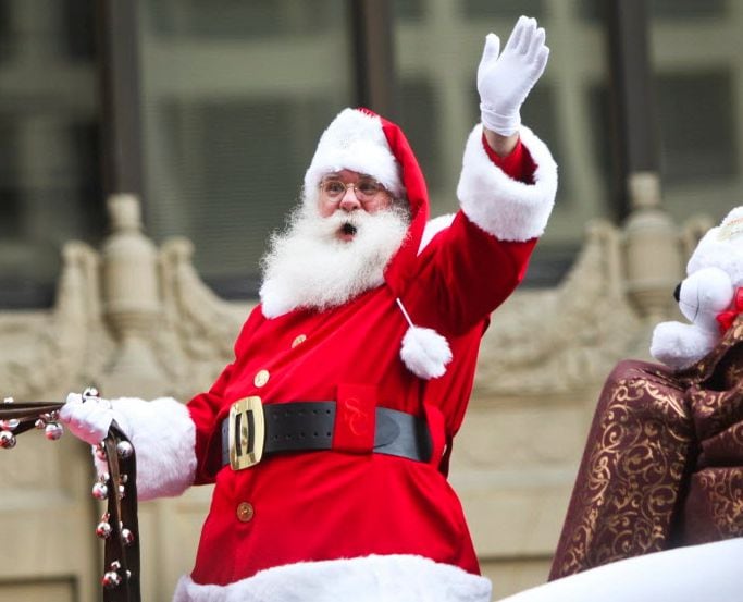 Santa Claus waves to the crowd during a Christmas parade.