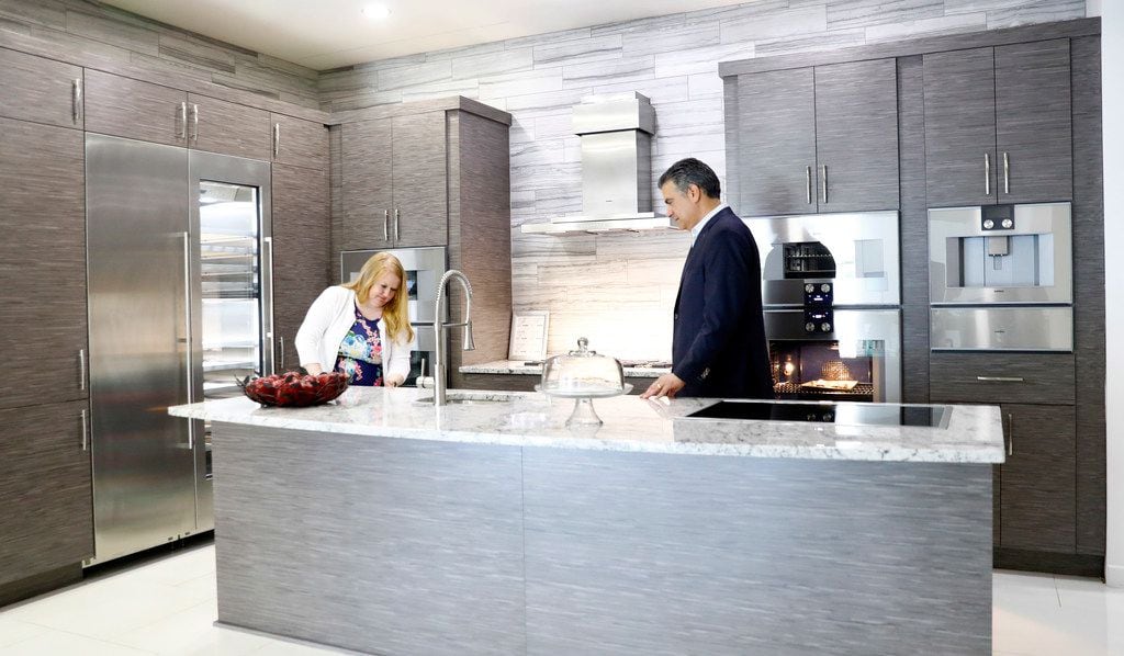 President Donald Trump's tariffs are already beginning to affect prices on appliances, including those made by Gaggenau, at Starpower in North Dallas. Starpower's Daniel Pidgeon (right) and Brandi Thompson test out Gaggenau appliances in one of their kitchens on Friday, July 13, 2018. 