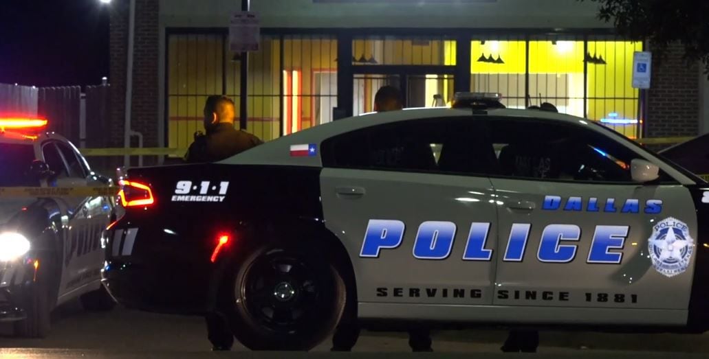 Dallas police officers stand outside a business near were a shooting victim was found Friday morning in South Dallas.