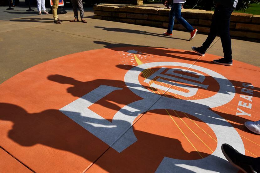 Shadows from freshman walk over a 50th anniversary logo celebrating 50 years of the...