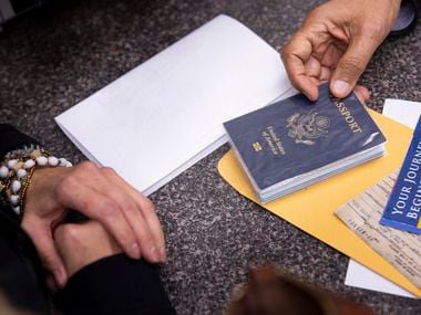 Amy Kirkland (a sinistra) di McKinney riceve il suo passaporto prima del suo volo per il Canada da Madan Goyal mercoledì 3 novembre 2021 al Passport and Visa Express di Plano.  (Juan Figueroa/The Dallas Morning News)