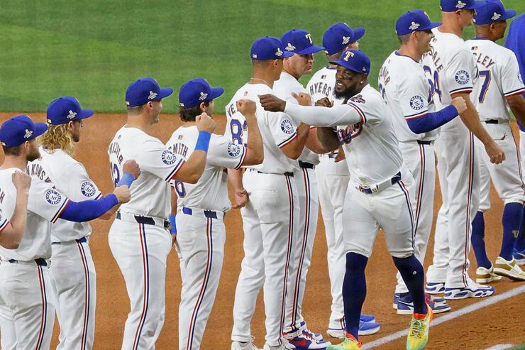 Texas Rangers right fielder Adolis Garcia (53) receives high fives from his teammates during...