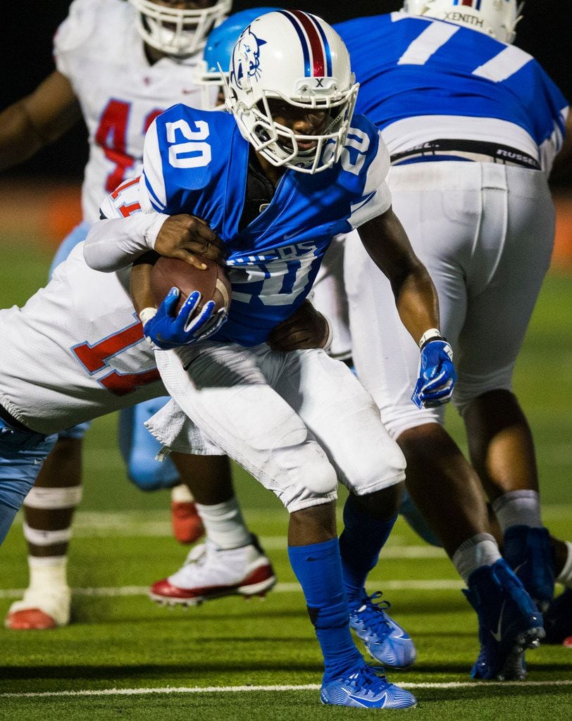 Duncanville running back Cameron Gray (20) is tackled by Skyline linebacker Jeremiah White...