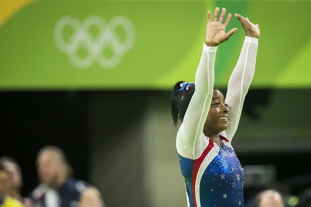 Simone Biles of the United States waves to the crowd after winning the women's gymnastics...