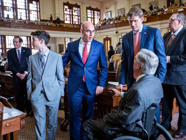 Gov. Greg Abbott (right, back to camera) chats with House Speaker Dennis Bonnen (2nd from...