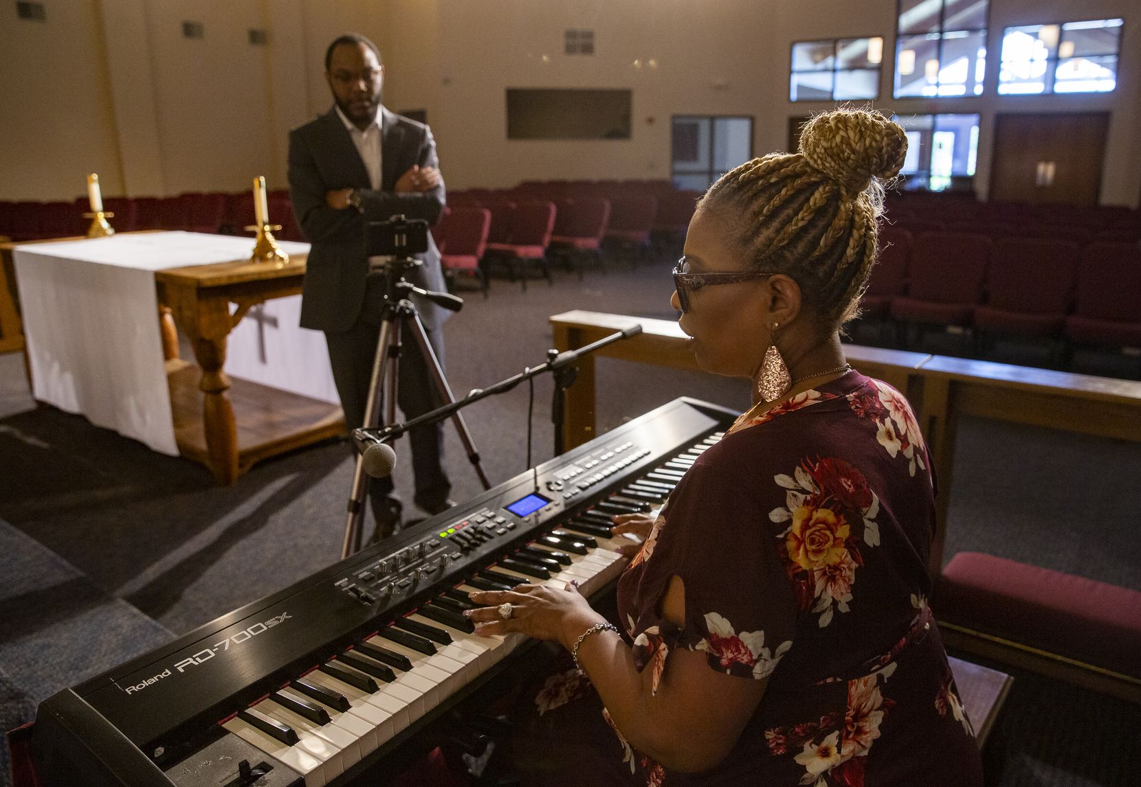 Pastor Bryant Phelps watches as music minister Regina Lee sings "I Need You to Survive" as...