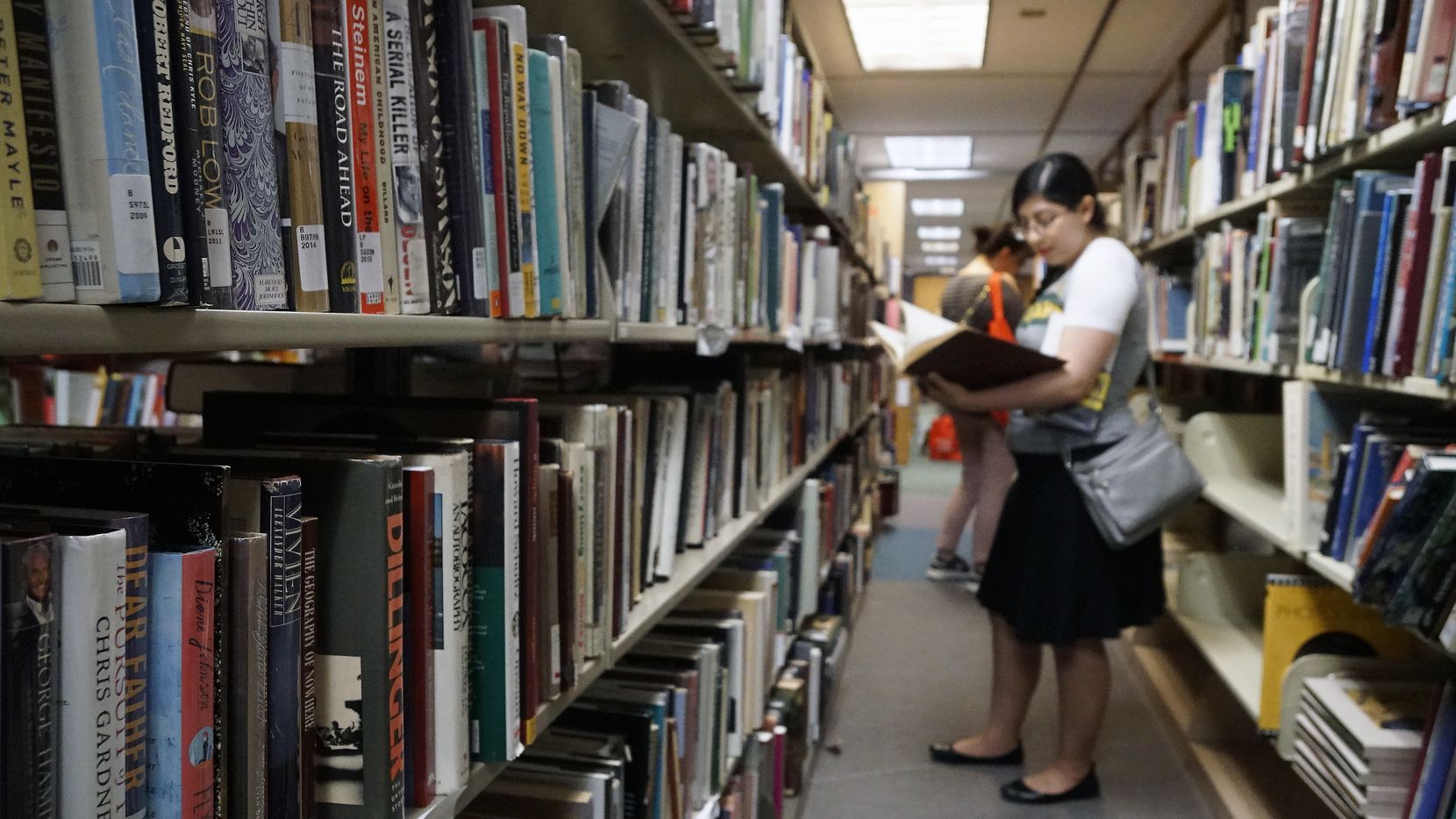 Priscilla Escobedo peruses the bookshelves during the Summer in the City discussion as part...