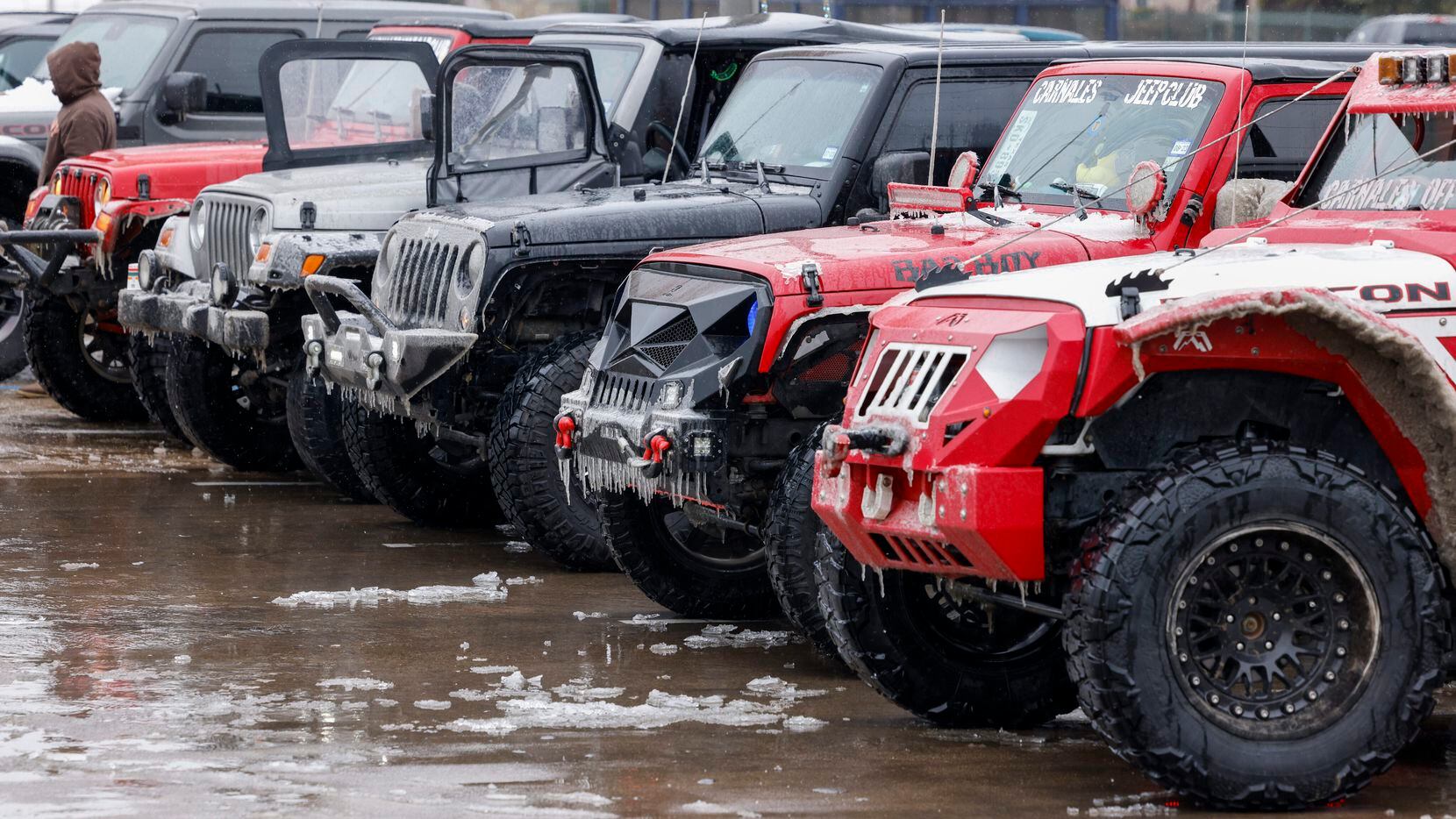 Several Jeeps of Carnales Off Road members sit in a parking lot as they regroup before...