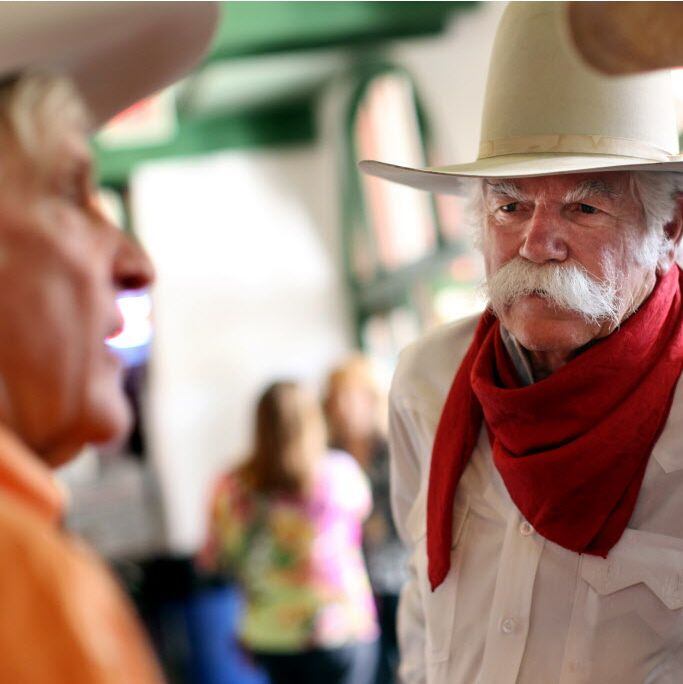 Steve Murrin talks with fellow cowboys and friends at the ribbon cutting celebration for the Texas Rodeo Cowboy Hall of Fame in Fort Worth.