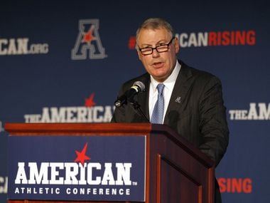 In this Aug. 4, 2015 file photo, American Athletic Conference Commissioner Mike Aresco addresses the media during an NCAA football media day in Newport, R.I. with Big 12 expansion talks looming. (AP Photo/Stew Milne)