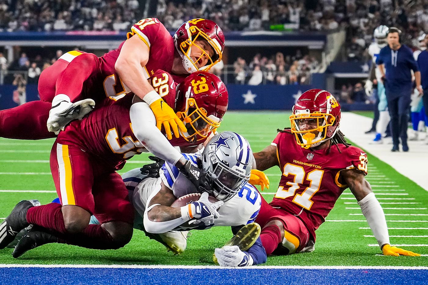 Dallas Cowboys running back Ezekiel Elliott (21) dives for a touchdown past Washington...