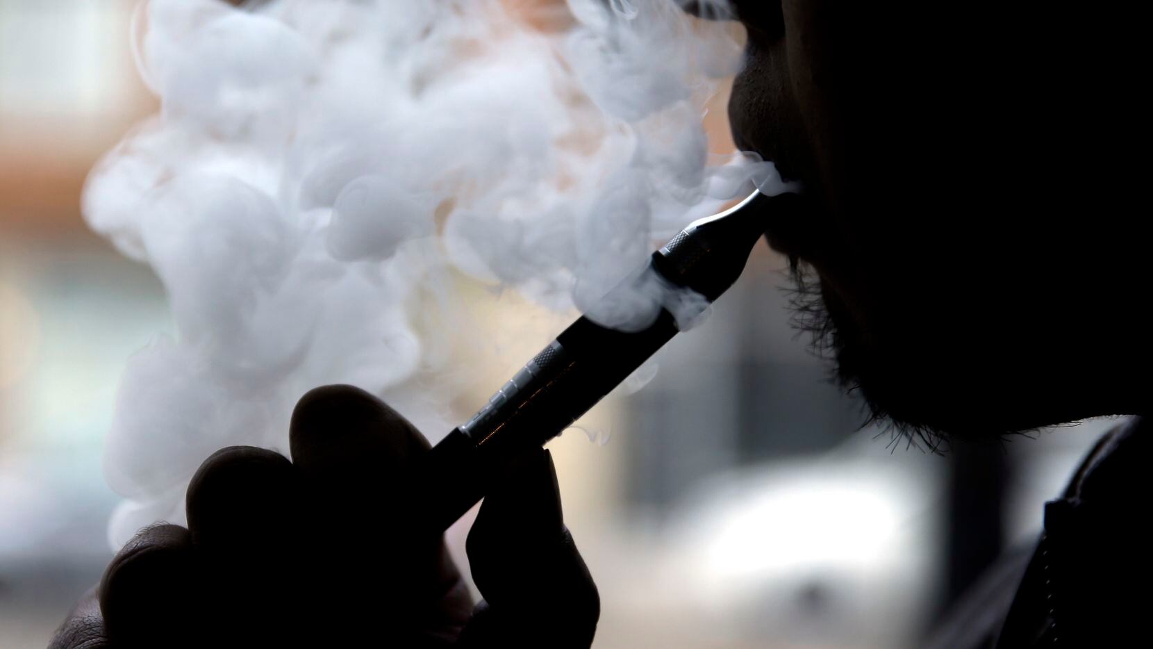 
A vaper puffs away on a battery-operated nicotine stick. Electronic cigarettes can save...