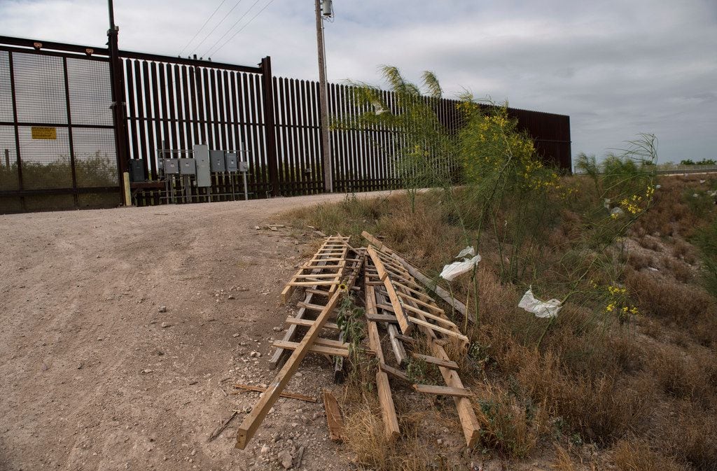 Ladders used by immigrants to scale walls and levees sit by the border fence near McAllen,...