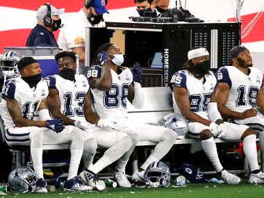 The Dallas Cowboys receiving corps of Ced Wilson (11), Michael Gallup (13), CeeDee Lamb (88), Noah Brown (85) and Amari Cooper (19) don their masks on the bench during the fourth quarter at AT&T Stadium in Arlington, Thursday, November 26, 2020. The Cowboys lost to the Washington Football Team, 41-16. (Tom Fox/The Dallas Morning News) 