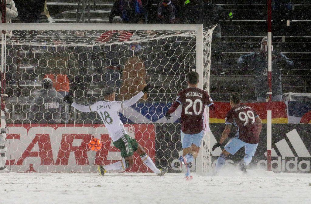 Colorado Rapids forward Andre Shinyashiki (99) scores the game-tying goal past Portland Timbers defender Julio Cascante (18) as Rapids forward Nicolas Mezquida (20) trails the play the second half of an MLS soccer game Saturday, March. 2, 2019 in Commerce City, Colo. (AP Photo/Joe Mahoney)