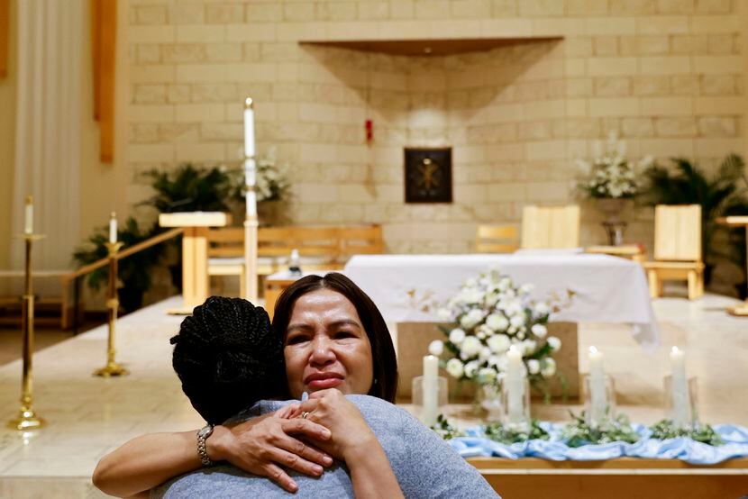 Parishioners embrace each other after a vigil and community Mass on Wednesday at St. Jude...