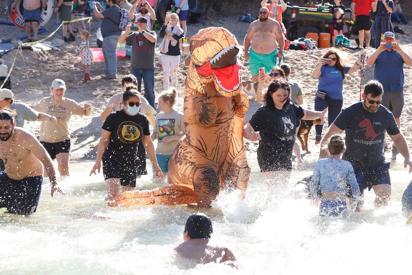 Erick Barbosa, 17, dons an inflatable dinosaur costume as he jumps into the Paluxy River...