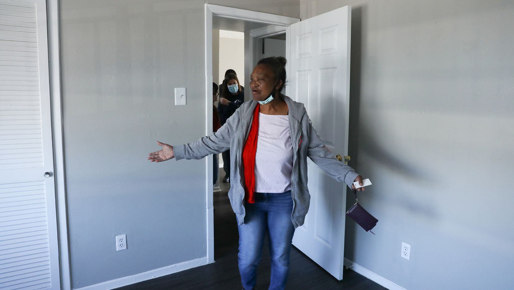 Patricia Freeman takes a first look at the bedroom in her new apartment in southern Dallas on November 19, 2021. Staff from The Bridge Homeless Recovery Center, Catholic Charities and the apartment complex follow her inside. (Liesbeth Powers/Special Contributor)