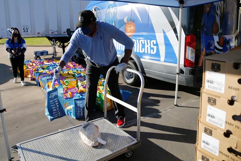 Former Dallas Mavericks player Cedric Ceballos prepares to give out food during a...
