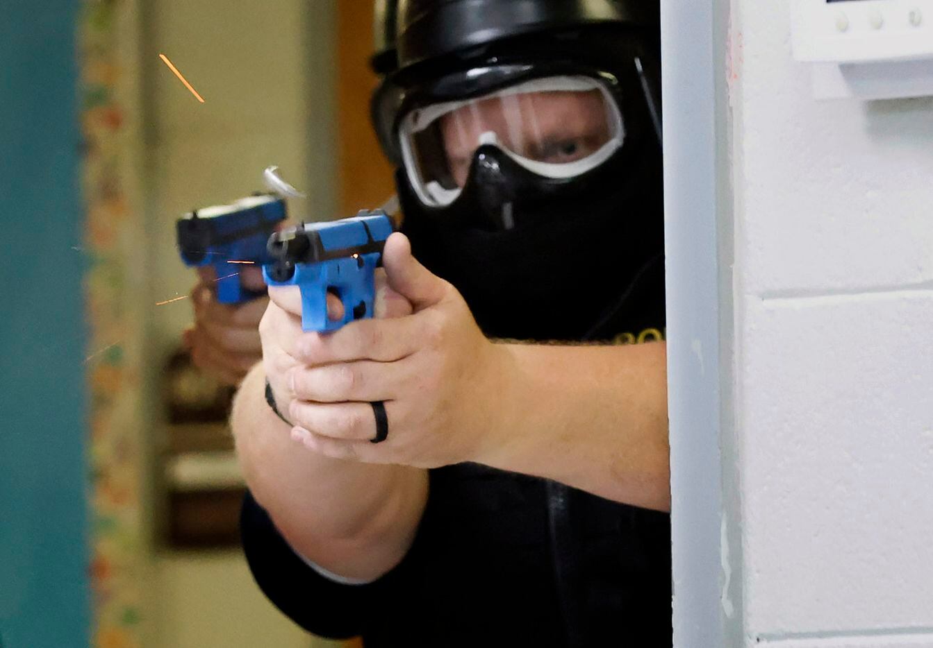 Athens Police Officer Roger Keith fires a soap-based marking cartridge at an active shooter...