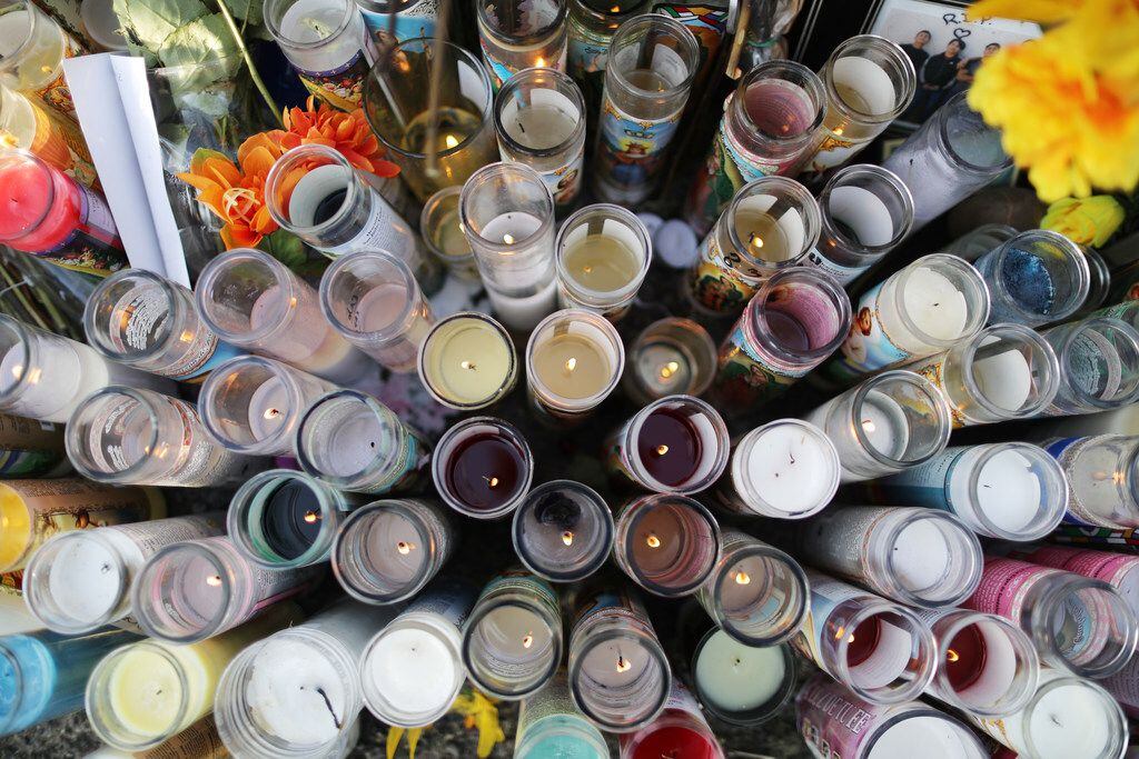 Candles are lit at a makeshift memorial honoring victims outside the Walmart where 22 people were killed in El Paso.