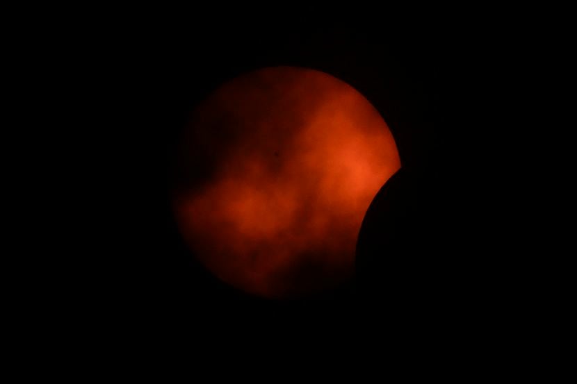 Las nubes cubren parcialmente la vista del eclipse en Arlington, Texas.