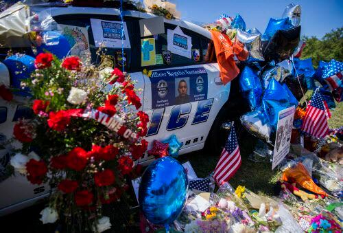 Un patrullero de la policía de Dallas en Northwest Highway está repleto de flores en...