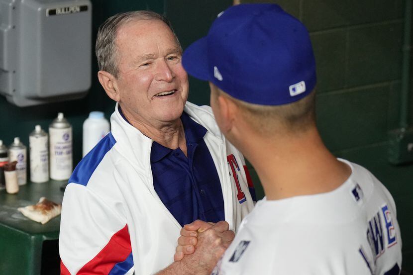 Former President George W. Bush shakes hands with Texas Rangers first baseman Nathaniel Lowe...
