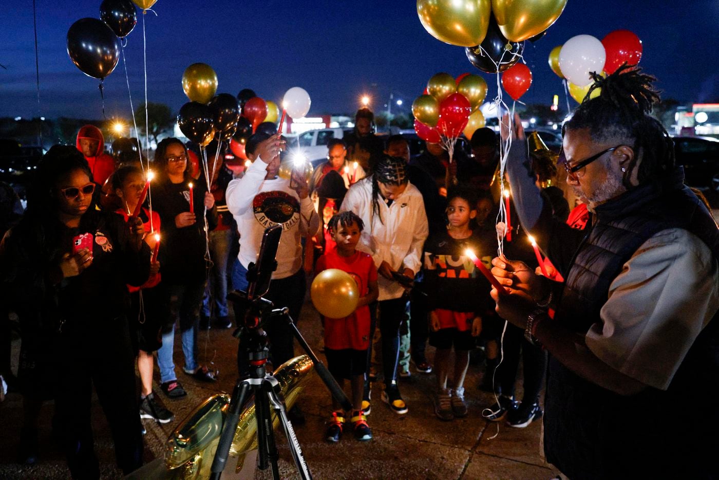 Preston Malone II says a prayer before a balloon release in memory of 11-year-old De’Evan...