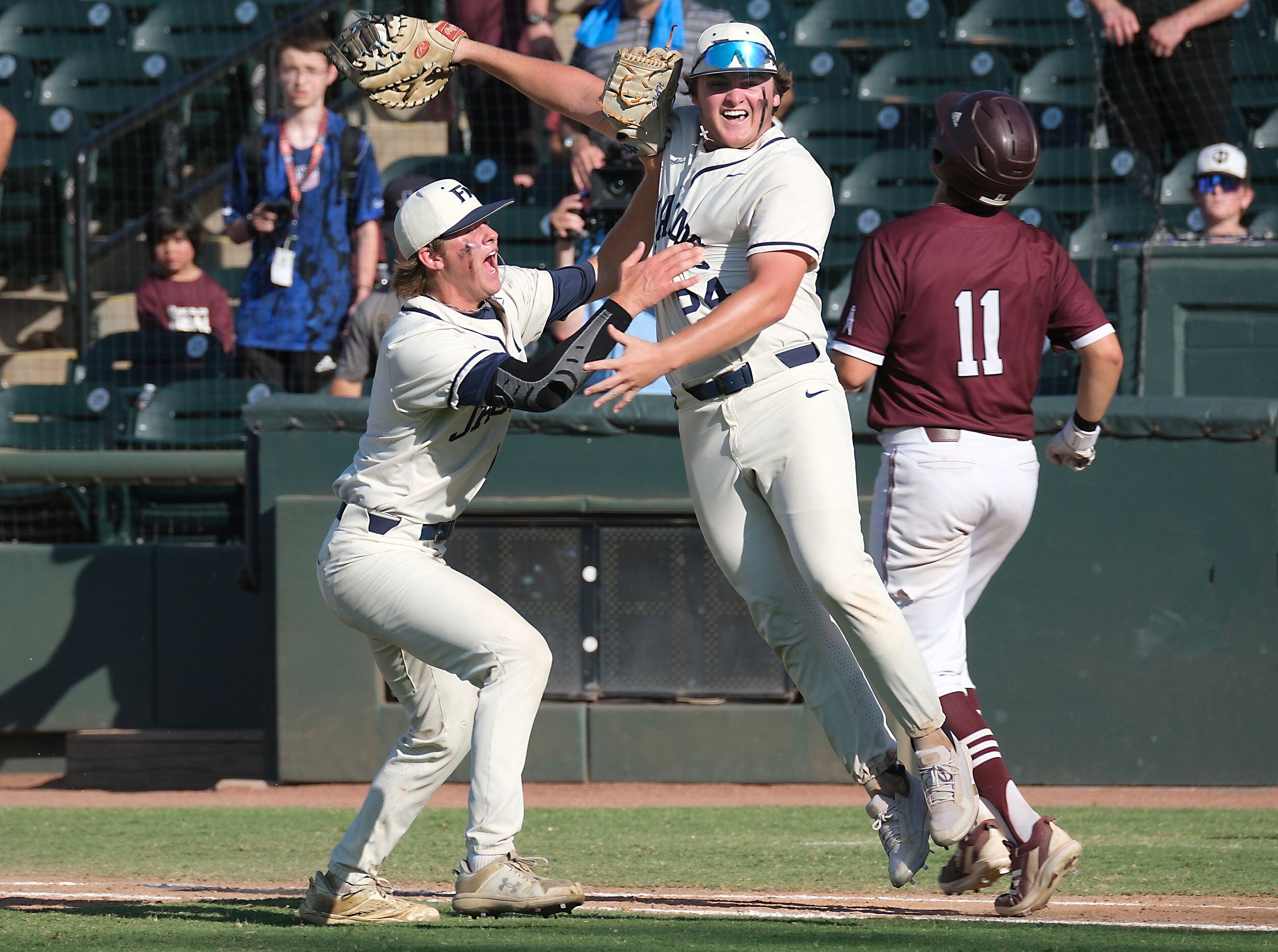 Flower Mound Cole Ridenour, (24), center, and Evan Rolison, (14), celebrate the last out of...