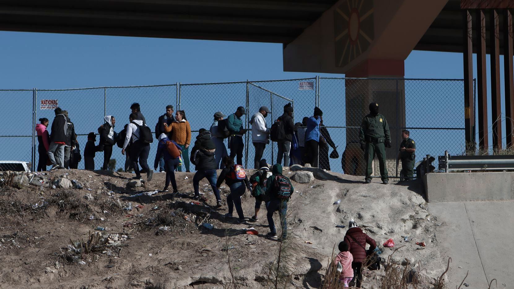 Migrantes cruzan la frontera entre México y Estados Unidos desde Ciudad Juárez, en México, y...