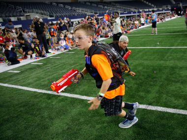 Kyson Henderson, 9, runs with a Nerf gun during Jared's Epic Nerf Battle 2 at AT&T Stadium...