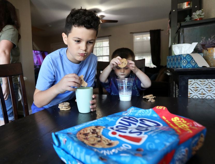 7-year-old Collin Clausi, left, and 3-year-old Dallin Clausi enjoy a snack at their home in...