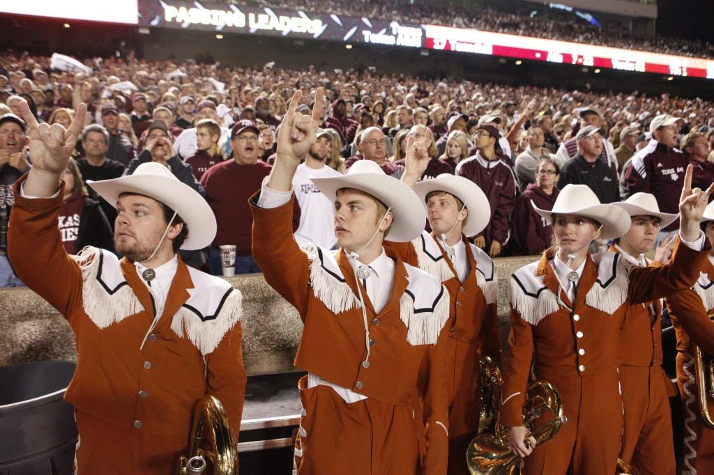 Members of the Longhorns "Show Band of The Southwest" marching band rase the "hook-em" horns...